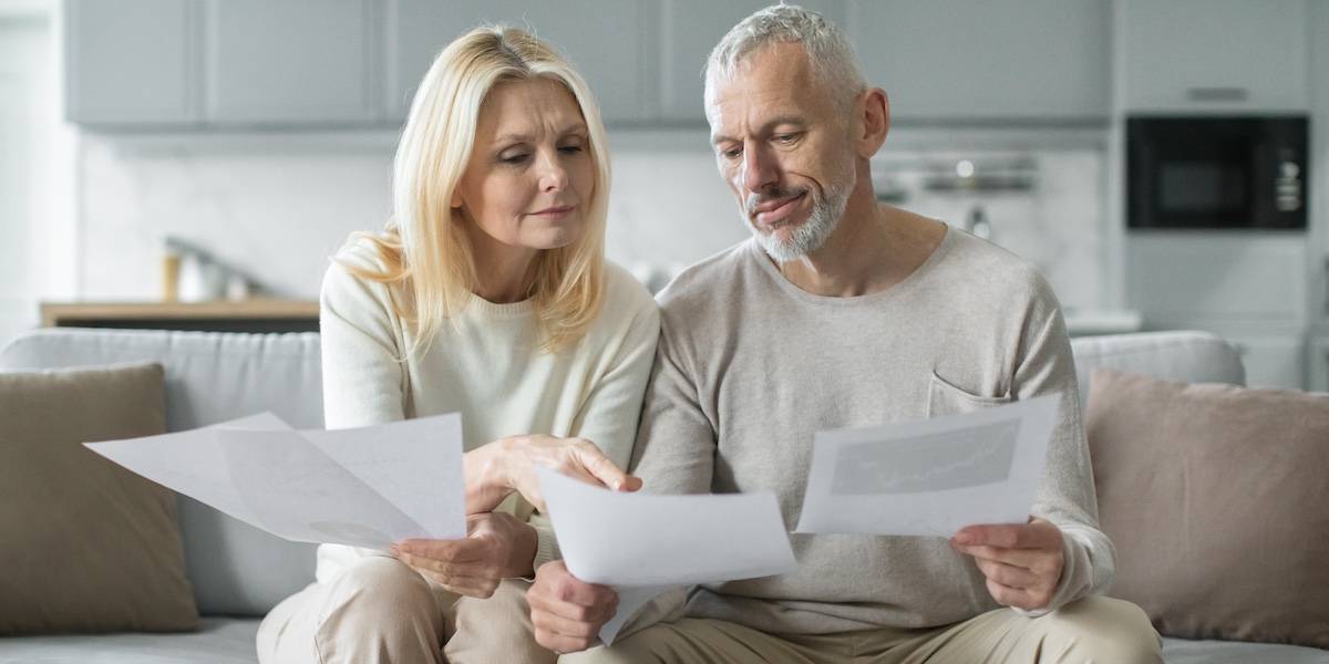 Couple reviews important documents together at home in the morning light
