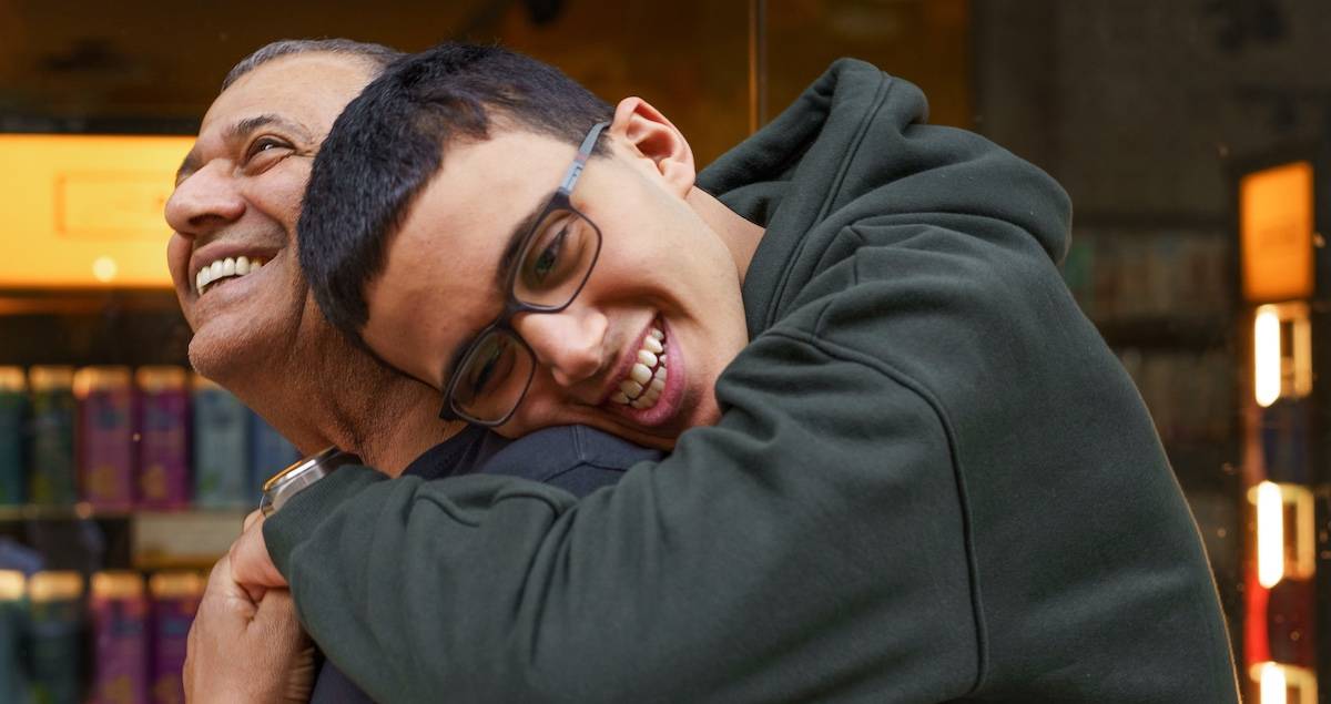 Senior Father And Son Hugging On The Mall.