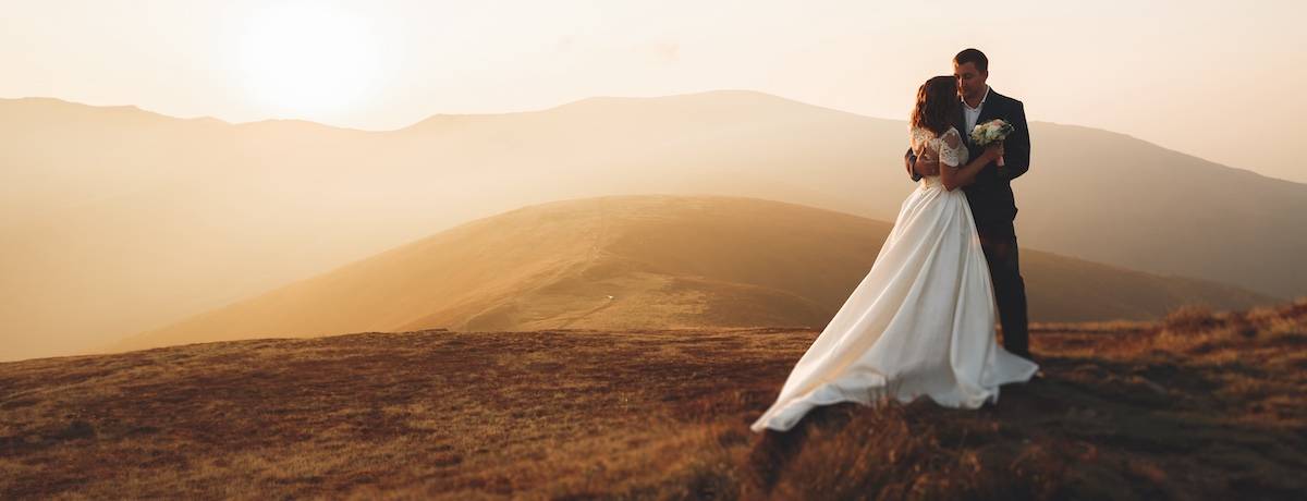 Wedding couple posing on sunset at wedding day. Bride and groom in love