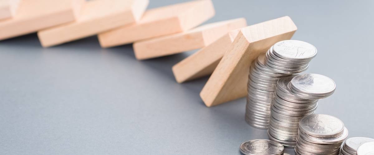 Domino effect impacts some of the heap of coins falling down, finance status, investment in domino effect concept