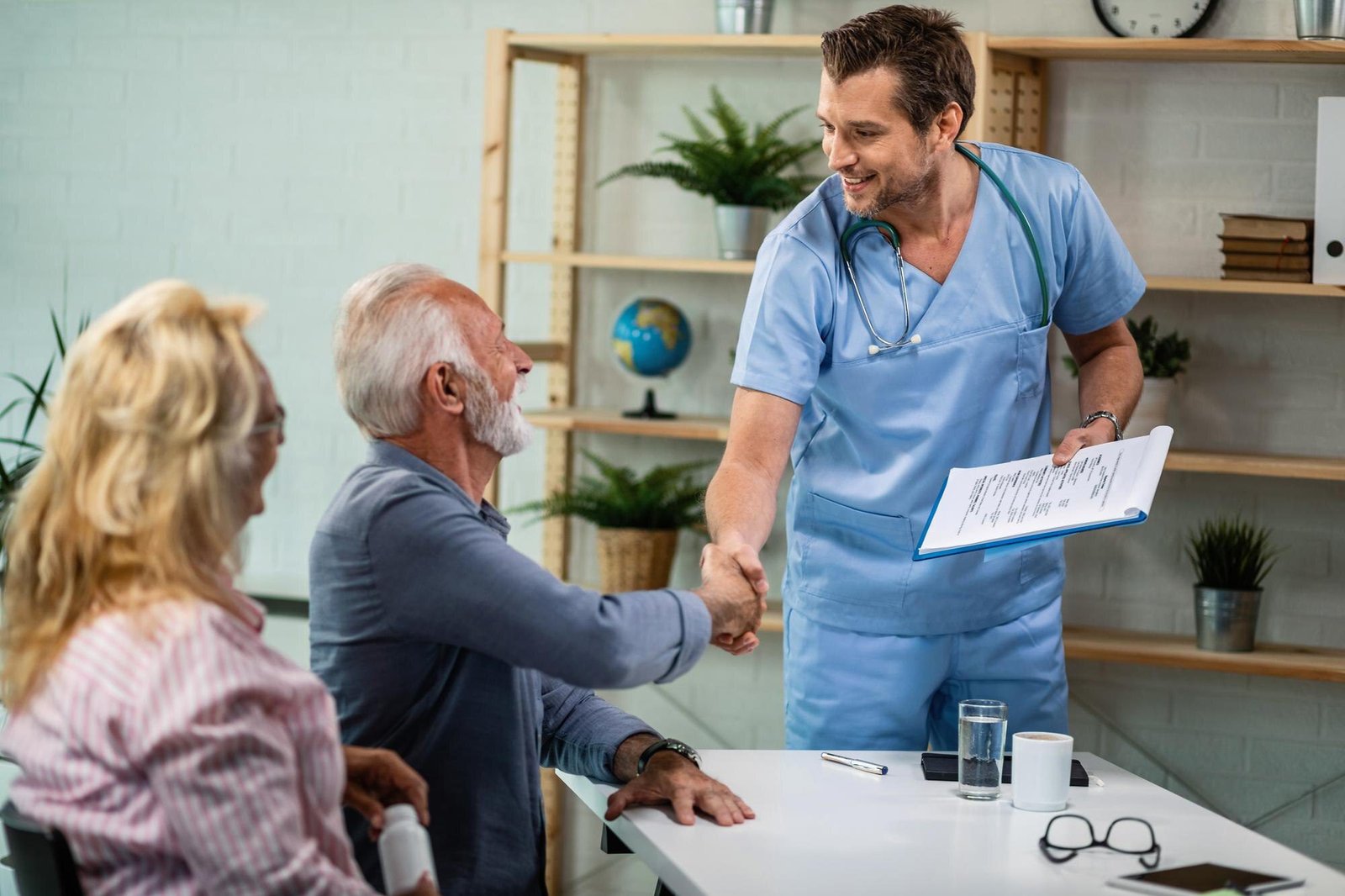 happy-healthcare-worker-mature-couple-greeting-his-office-men-are-shaking-hands_637285-1495