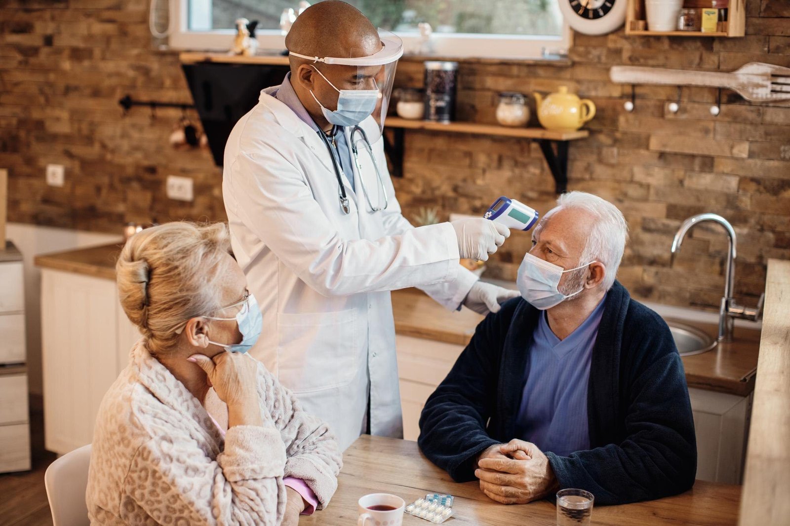 senior-couple-getting-their-temperature-measured-by-african-american-doctor-home-visit_637285-11447