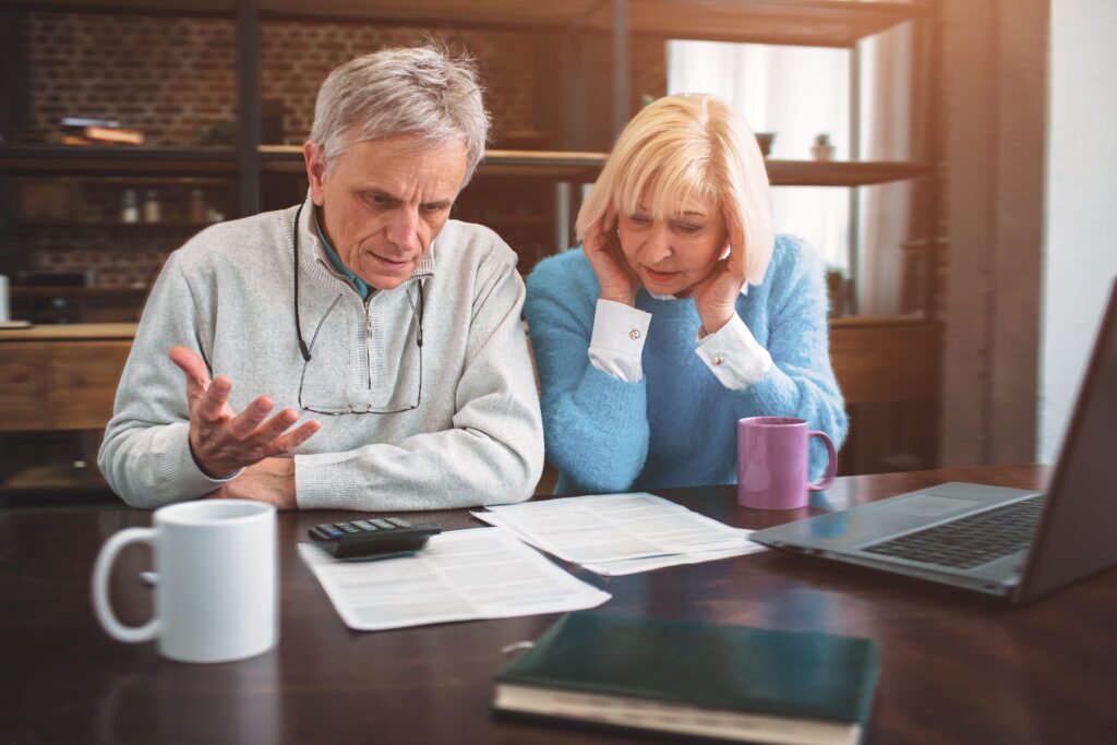 Top Medicare Mistakes Denver Residents Make During Annual Enrollment (And How to Avoid Them) | Aspen Financial & Insurance in Fort Collins, CO | Annuities in CO | Life insurance in CO Professional man and woman sitting together reviewing business documents.
