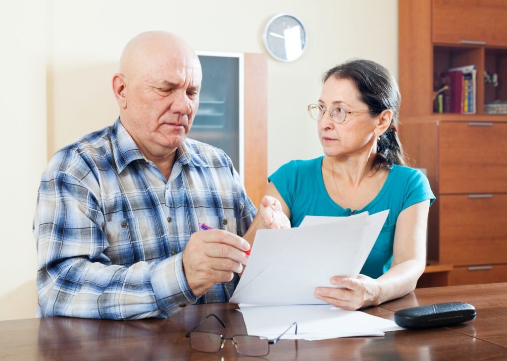 Mature couple filling out a questionnaire for insurance enrollment.