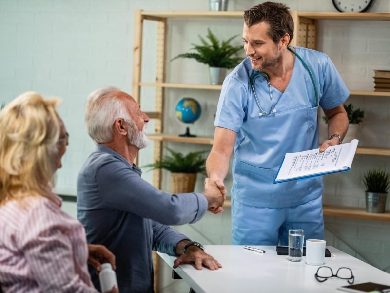 happy-healthcare-worker-mature-couple-greeting-his-office-men-are-shaking-hands_637285-1495
